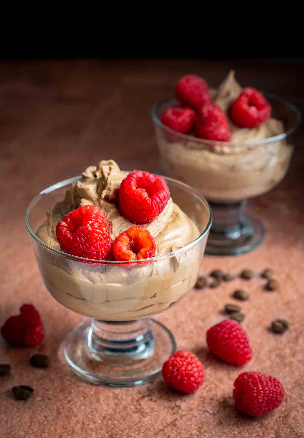 Three ingredient coffee mousse with raspberries in glass dishes.