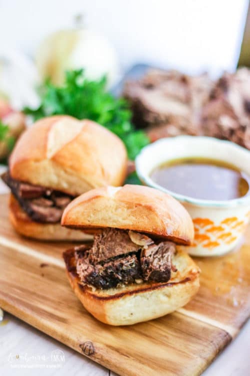 Slow cooker Italian beef sandwiches on a wooden serving tray.