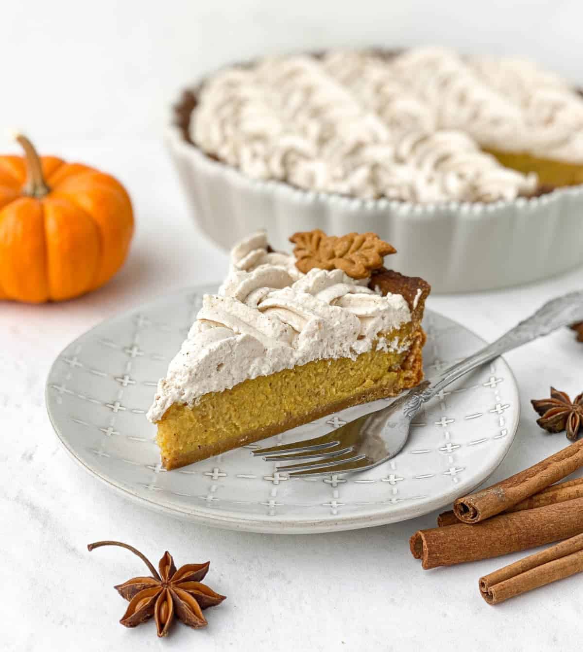 Gingerbread pumpkin pie serving on a plate with a fork.