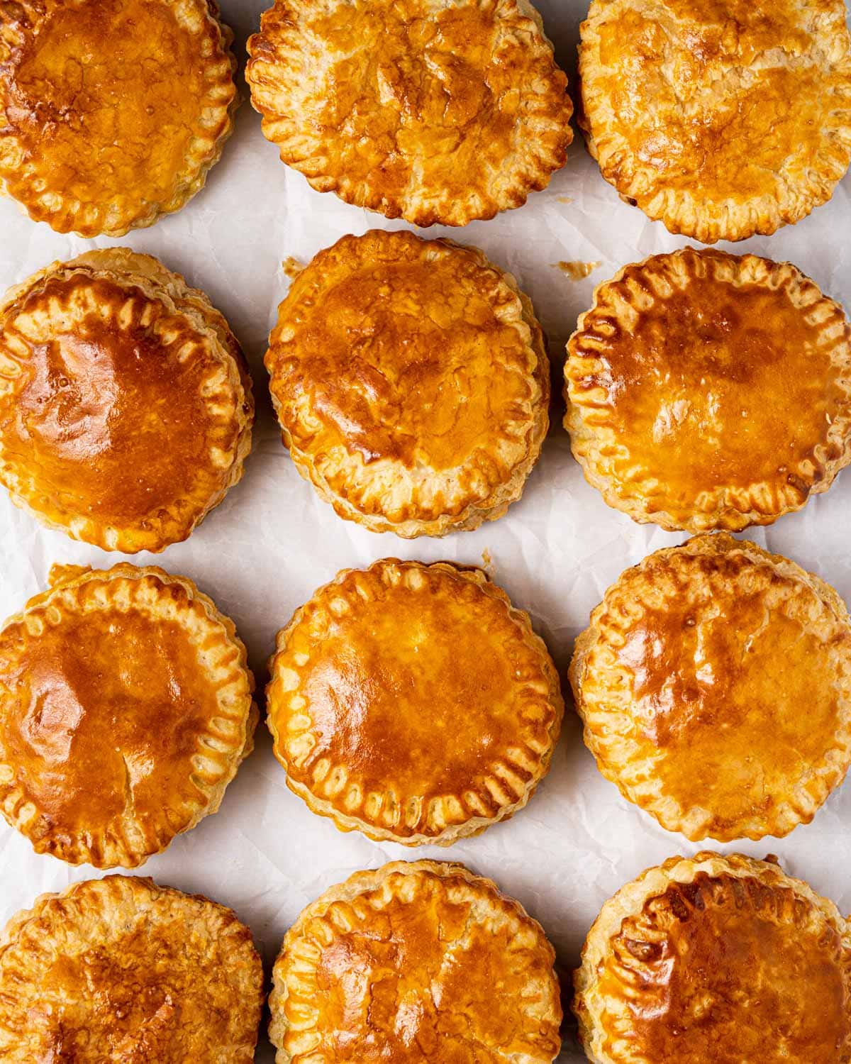 12 beautiful Vietnamese meat pies on parchment paper.