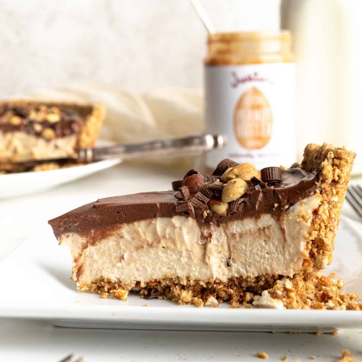 Slice of chocolate peanut butter pie with pretzel crust on a white plate.