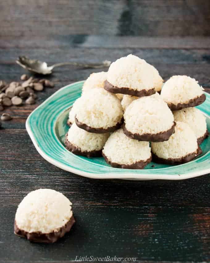 Coconut macaroons dipped in chocolate on a torquoise plate.