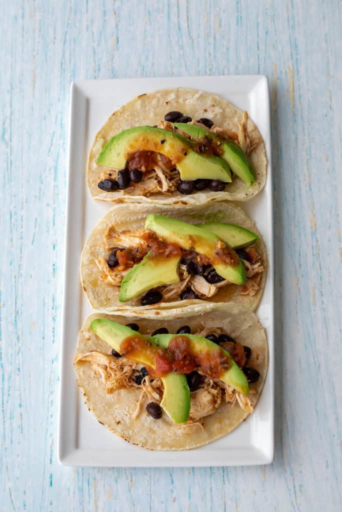 Five ingredient slow cooker chicken tacos on a square plate.