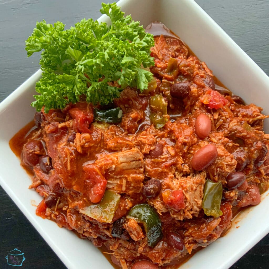 Slow cooker chili in a square bowl.