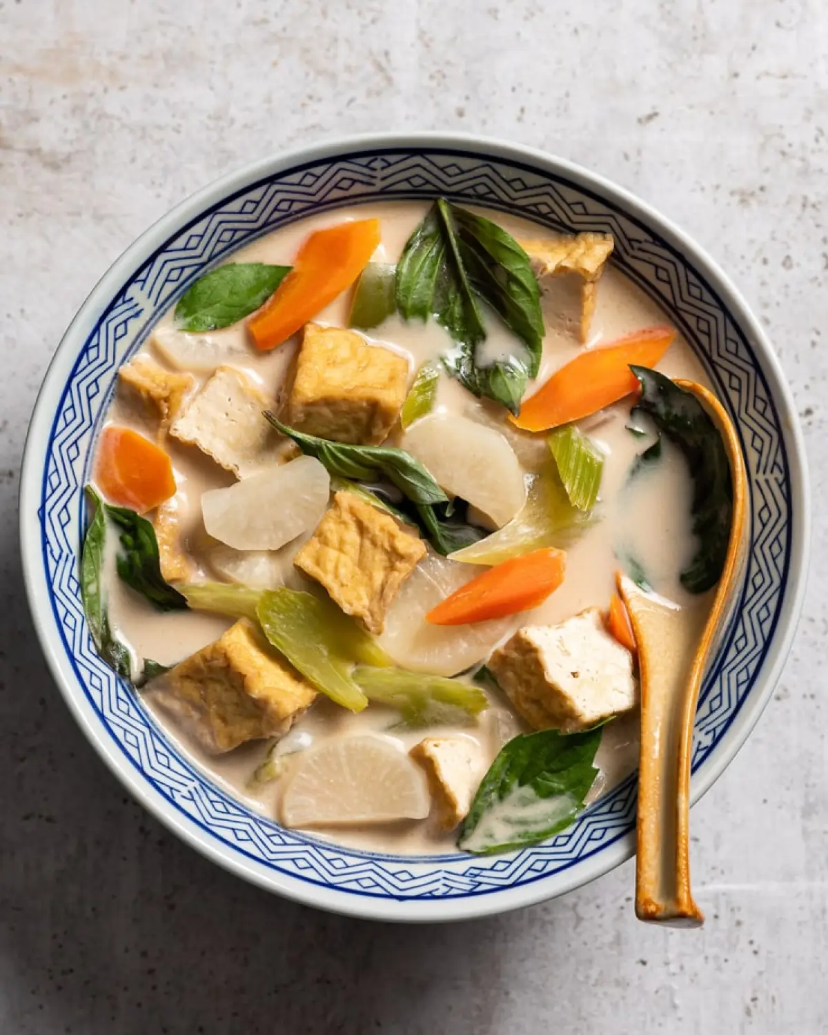 Bowl full on coconut basil soup with vegetables.