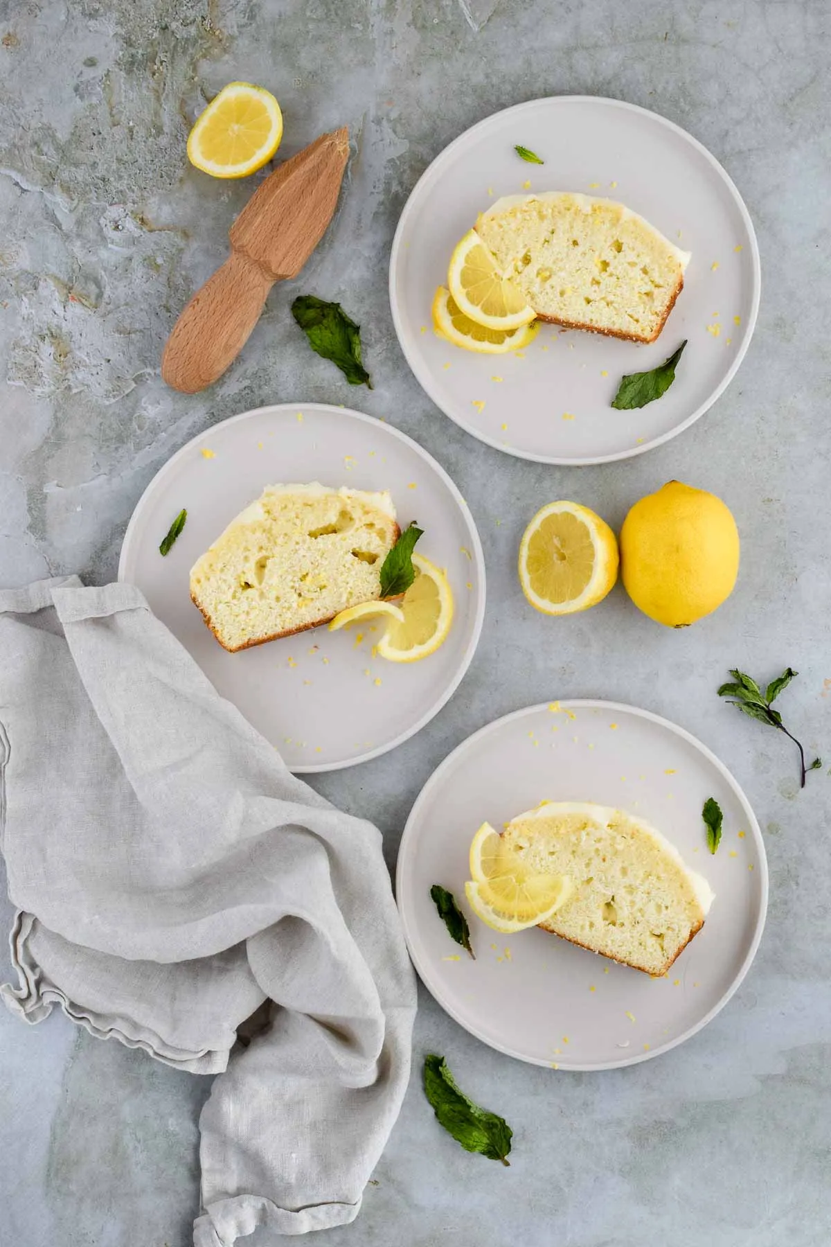 Greek yogurt lemon quick bread on a saucer with halved and whole lemon.