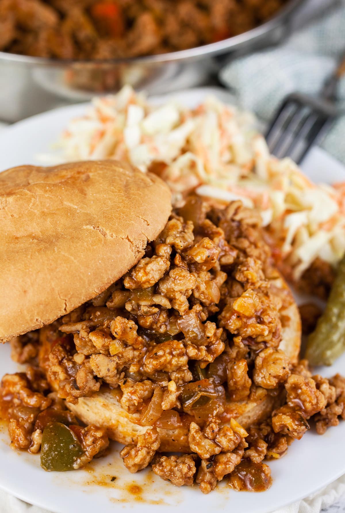 Ground chicken sloppy joes on a plate with coleslaw.