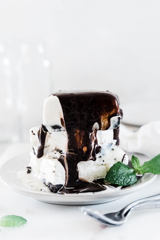 Stacks of slices of mud pies with chocolate sauce dripping down the side.