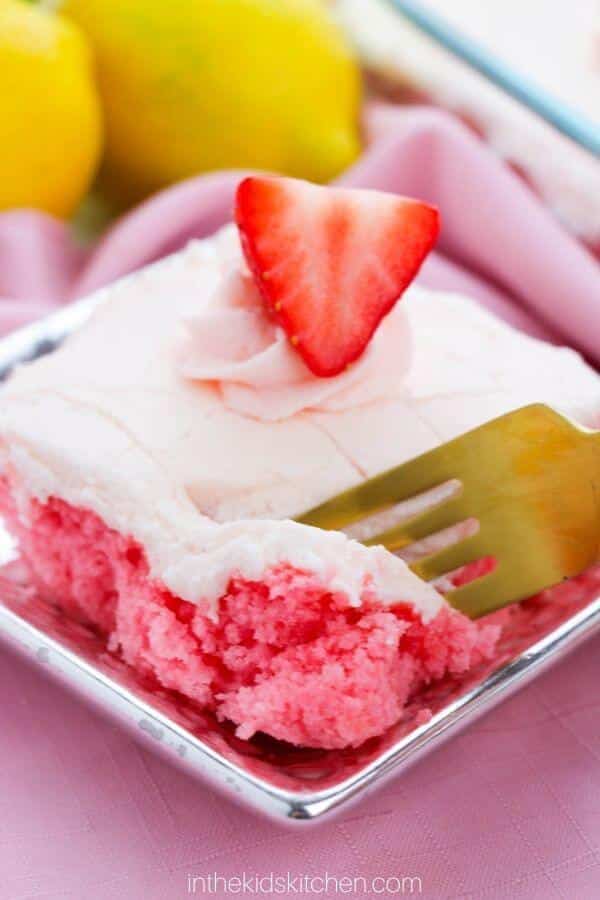 Slice of strawberry soda cake with cream cheese ice cream and a slice of a strawberry.