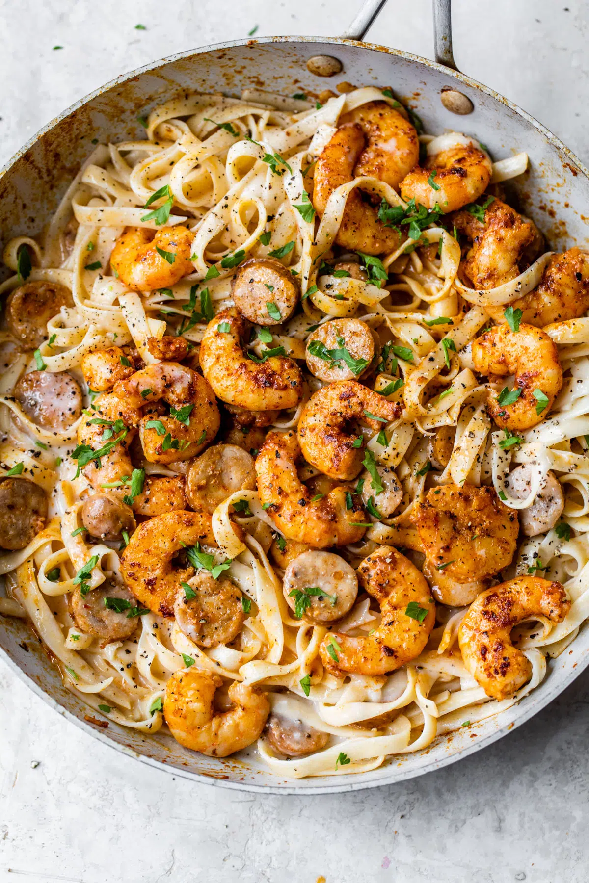 Cajun shrimp alfredo in a pan with sausage.