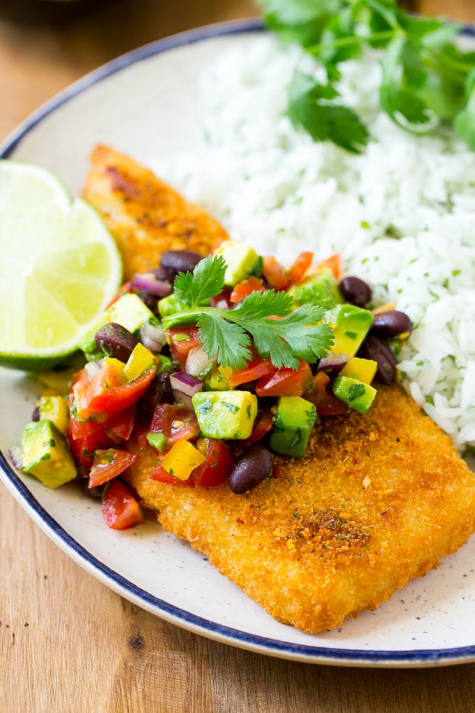 Fajita fish with avocado salsa and rice on a plate.