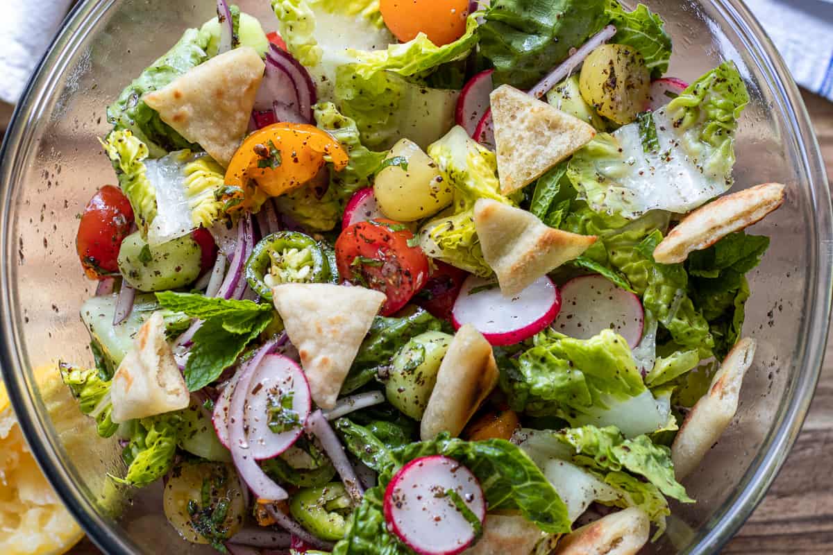 Lebanese fattoush salad with pita bread in a clear bowl.