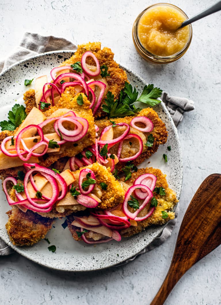 Pork schnitzel with pickled onions and apples, and apple sauce.