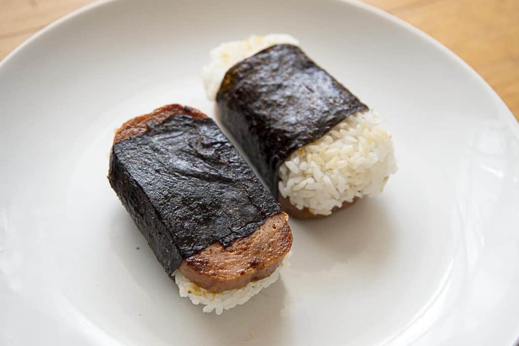 Two spam musubi on a white plate.