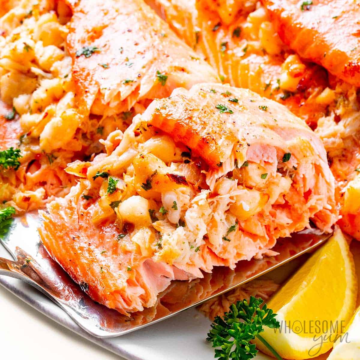 Crab stuffed being picked up with a spatula from a platter.