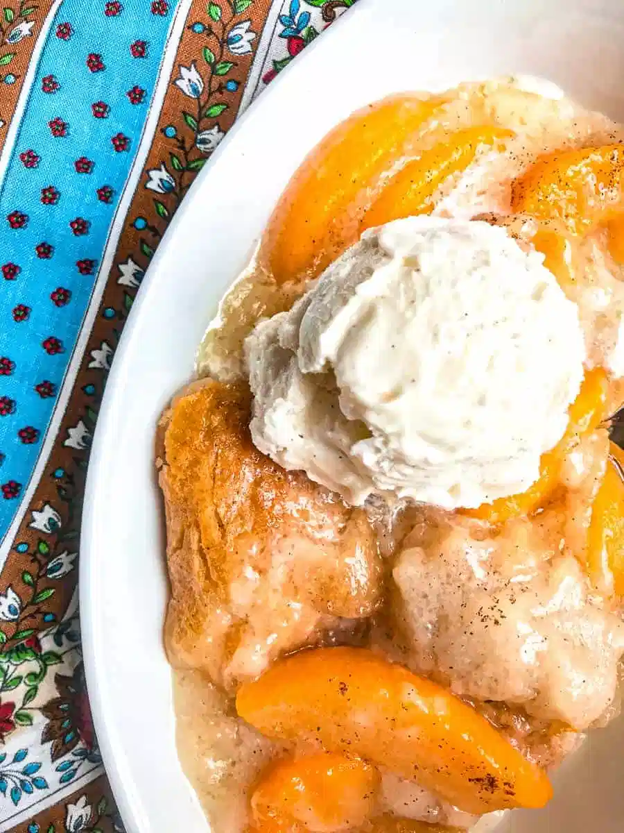 Southern peach cobbler in a white bowl.