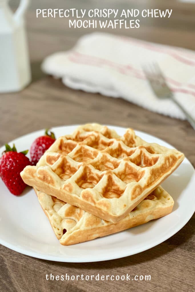 Two mochi waffles on a white plate with strawberries.