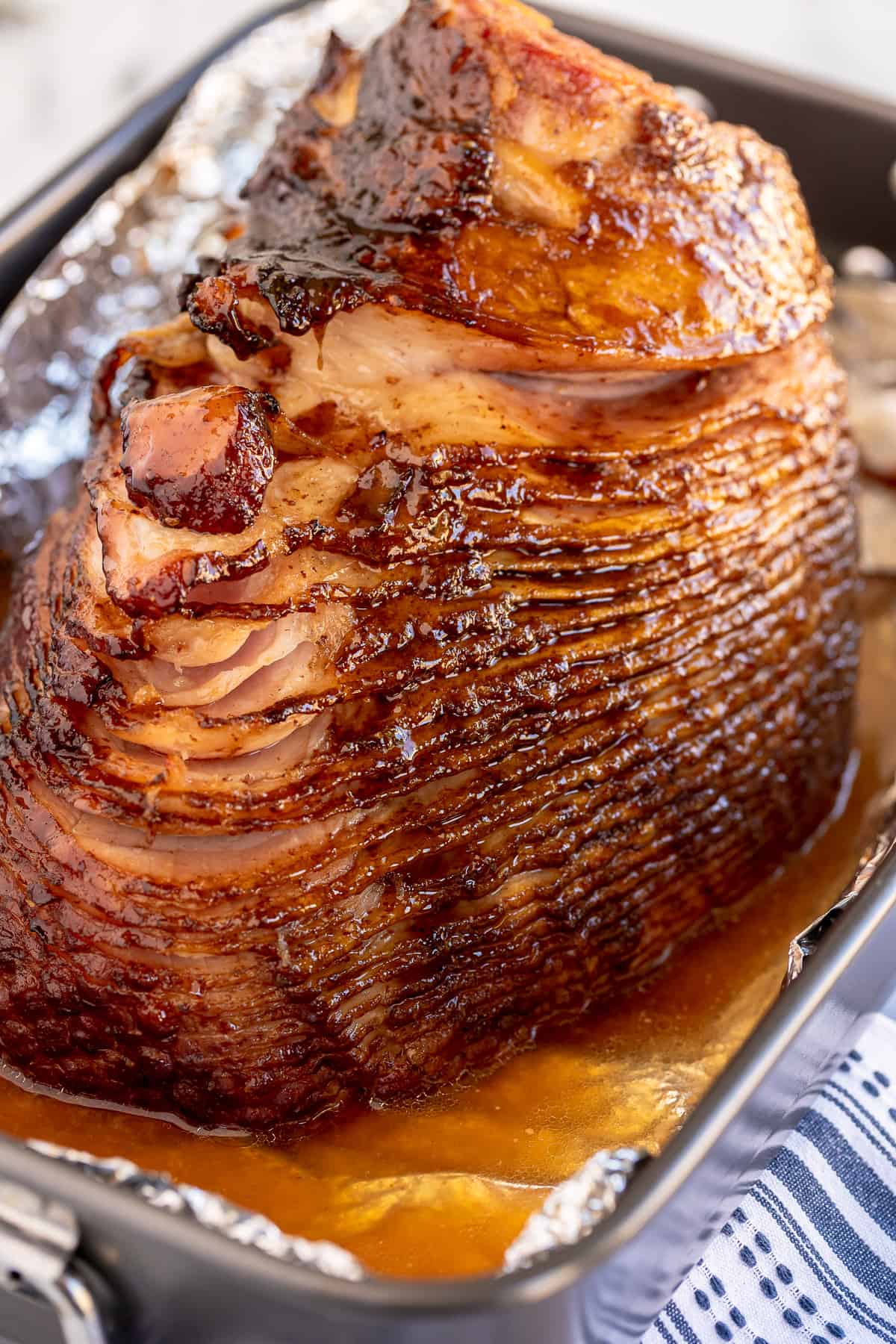 Thinly sliced maple glazed spiral ham on a baking tray.