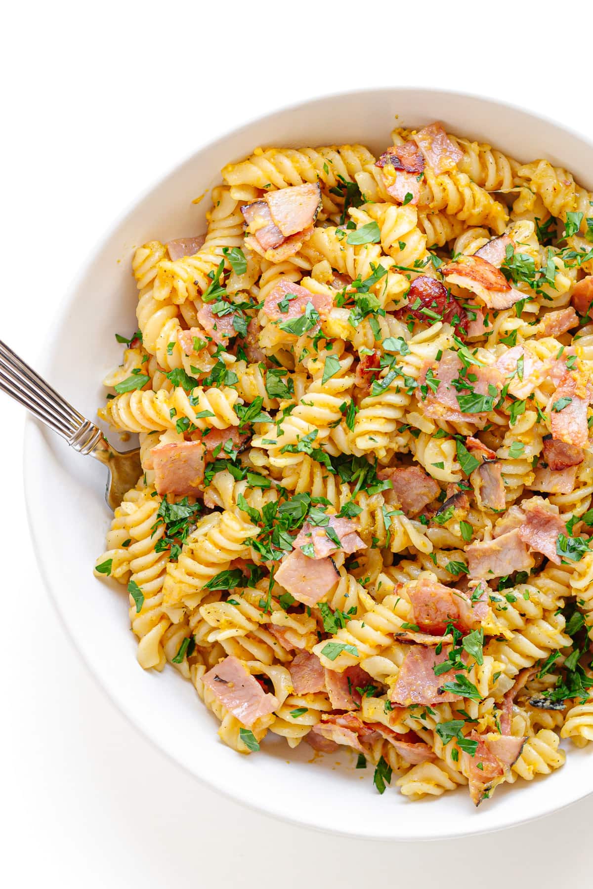 German ham and egg pasta in a white bowl.