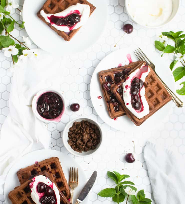 Black forest waffles with whipped cream  , chocolate chips, and cherry sauce.