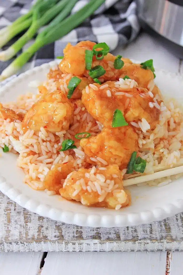 Instant pot sweet and sour chicken with rice on a white plate.