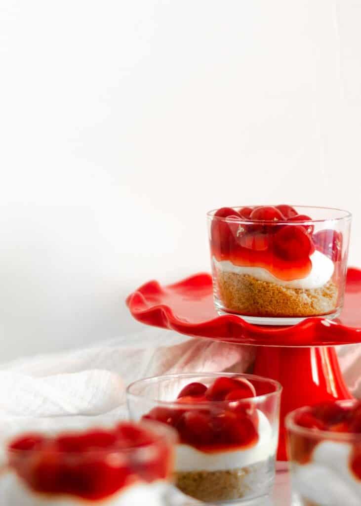 No bake cherry cheesecake parfaits in a small clear dish.