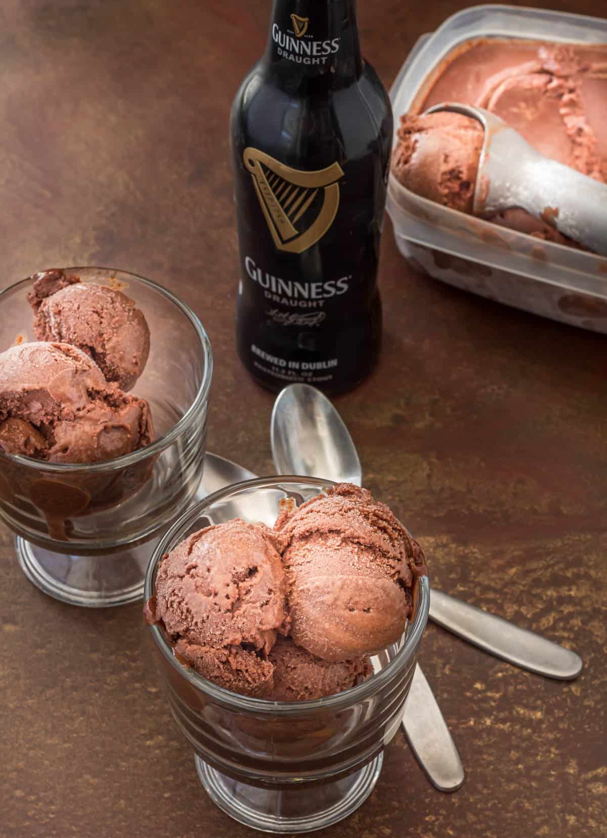 Raspberry chocolate sorbet in clear containers with Guinness bottle and spoons in the background.