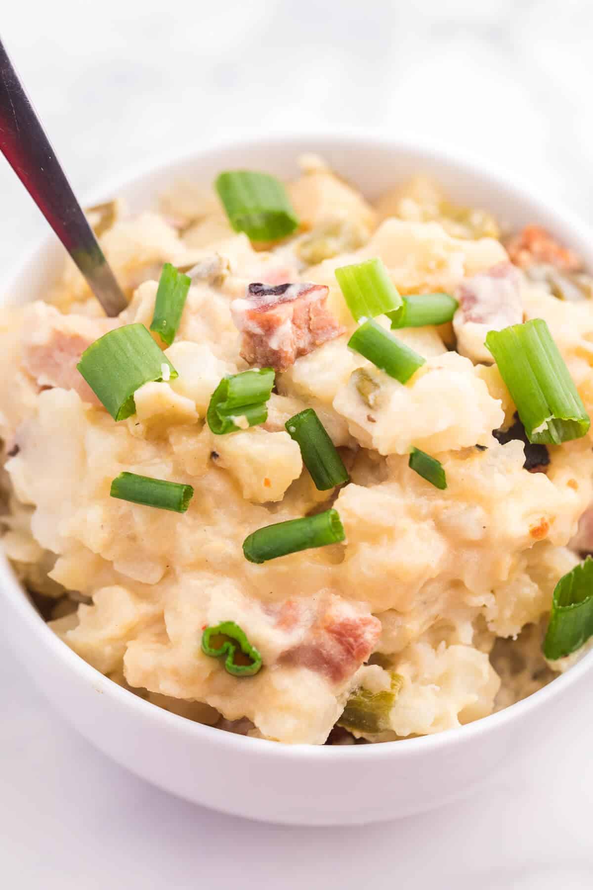 Slow cooker ham and potato hash in a white bowl.