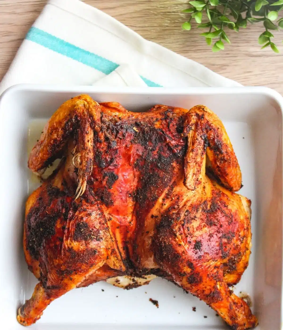 Air fryer spatchcock chicken on a white serving tray.