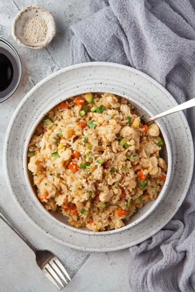 Chicken fried rice on a white plate.