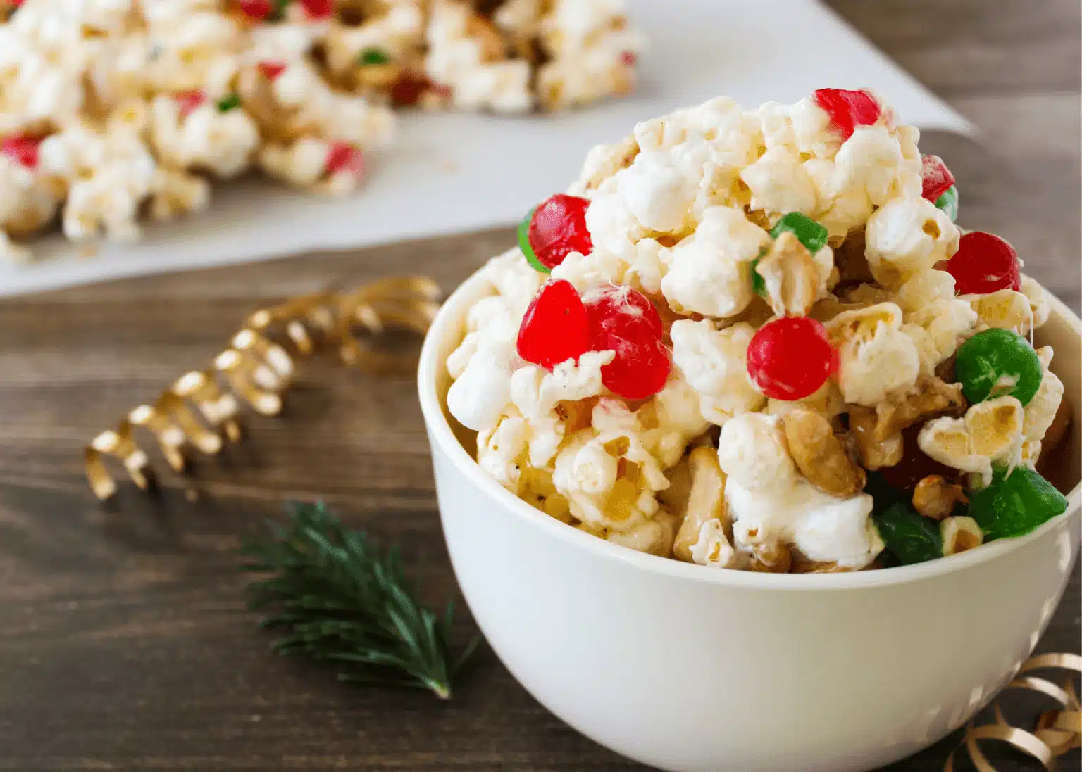 Christmas popcorn recipe with dots candy and cashews in a white bowl.