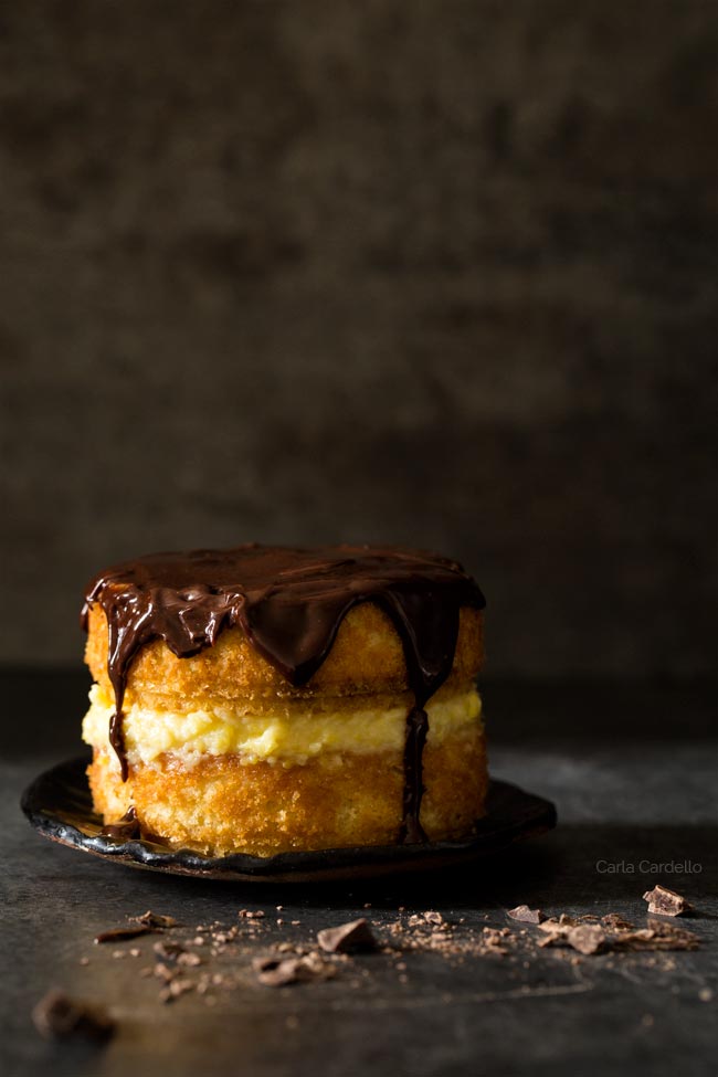 Mini Boston cream pie for two on a plate with a dark background.