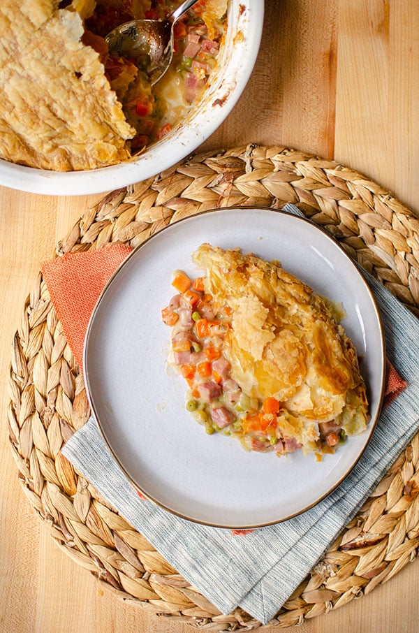 Slice of ham pot pie on a white plate.