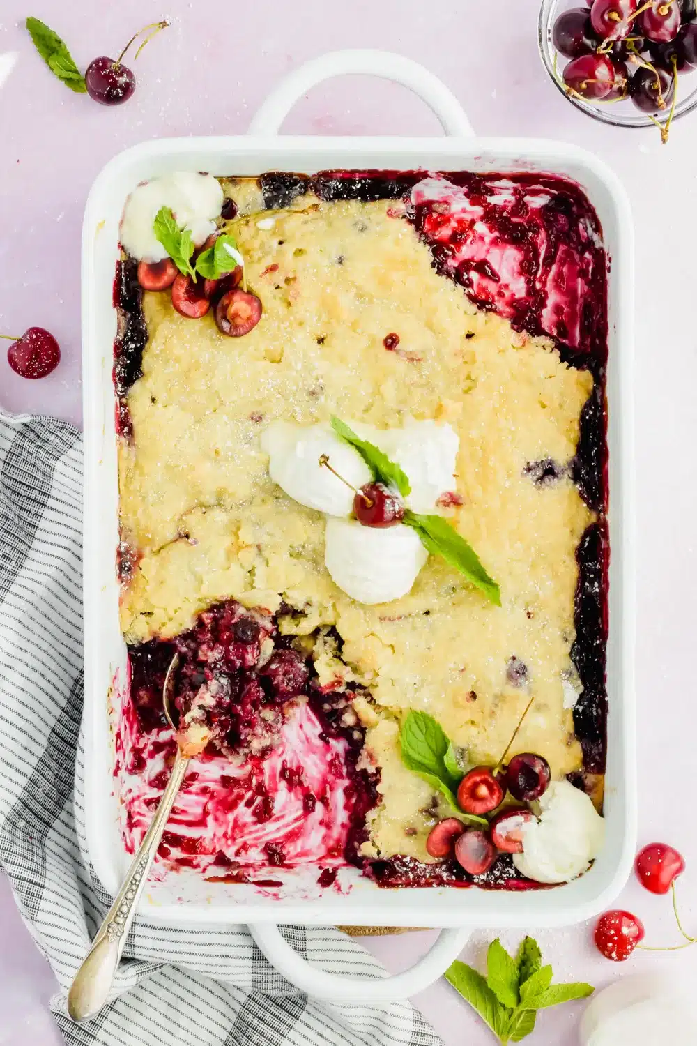 Cherry blueberry cobbler in a white baking pan.
