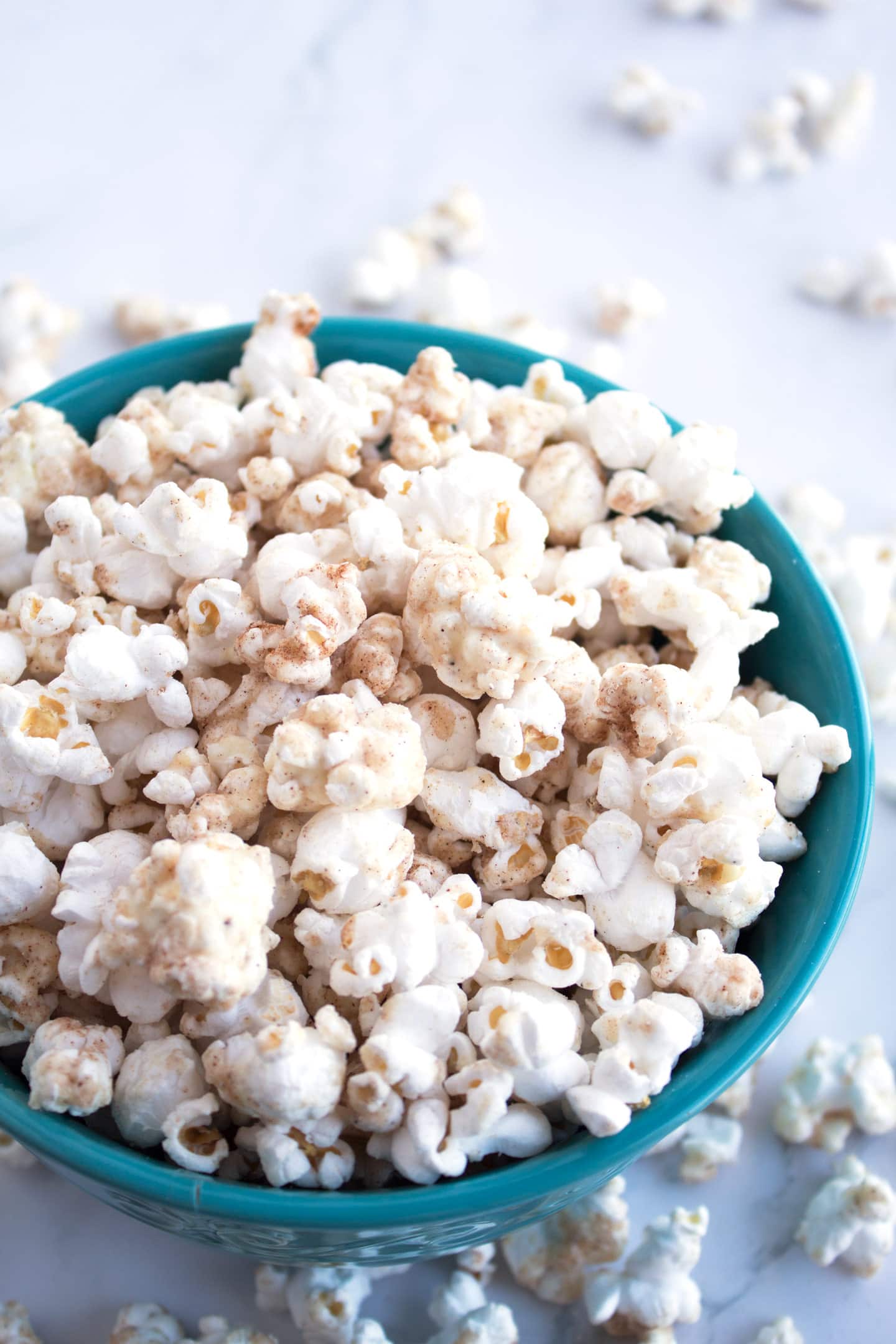 White chocolate churro popcorn in a blue bowl.