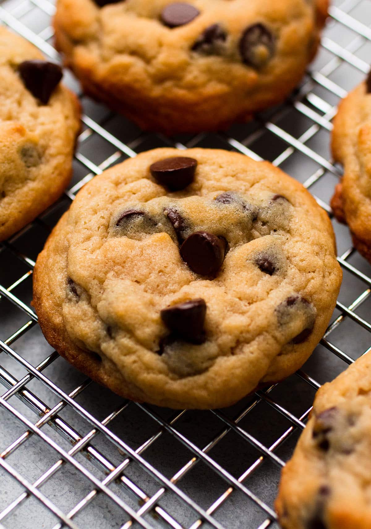 A handful of chocolate chip cookies on a cooling rack.