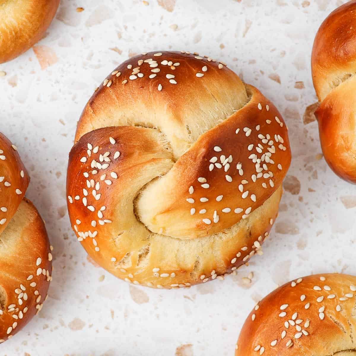 Challah rolls on a white countertop.