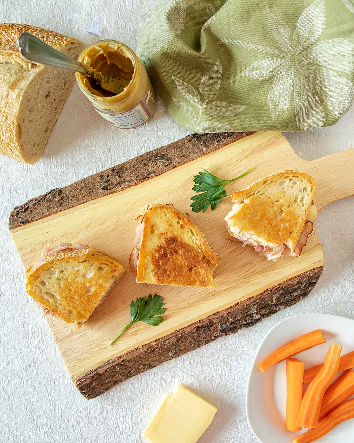 Grilled ham and cheese on a wooden display board.