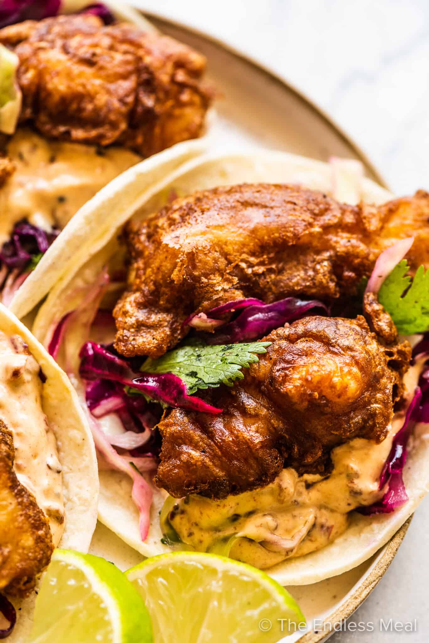Beer battered fish tacos with sauce and cabbage.