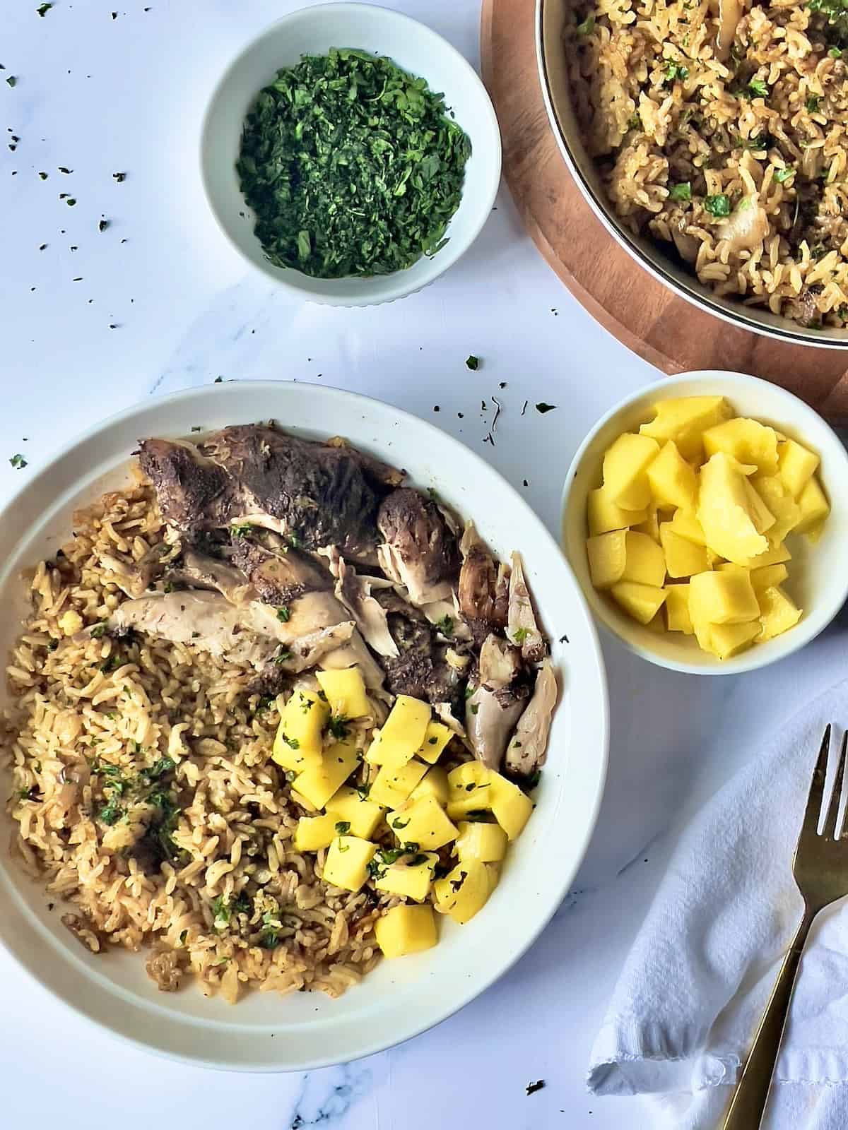 Instant pot Jamaican jerk chicken and rice with pineapple on a white plate.