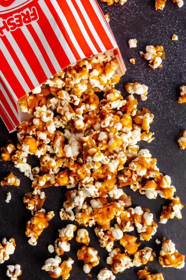 Spilled over caramel popcorn on a dark background.