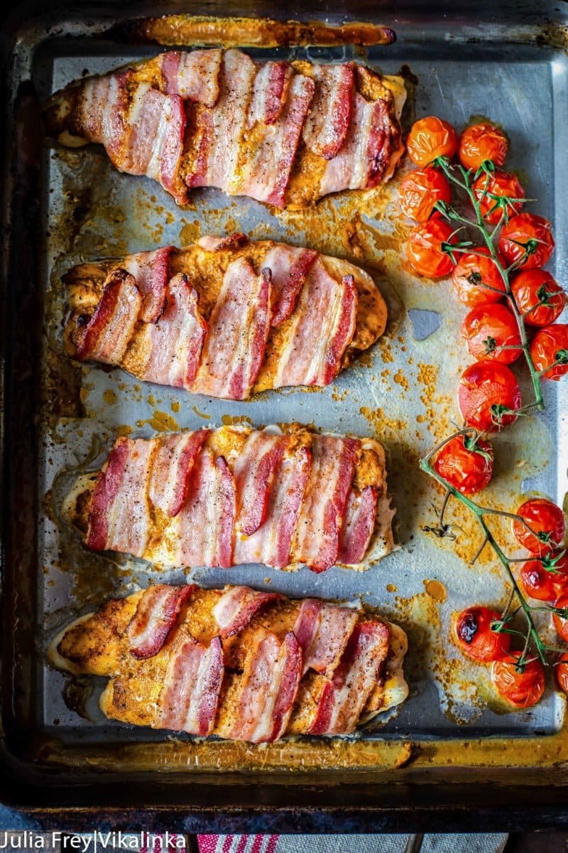 Bacon wrapped fish with sun-dried tomato pesto on a baking pan.