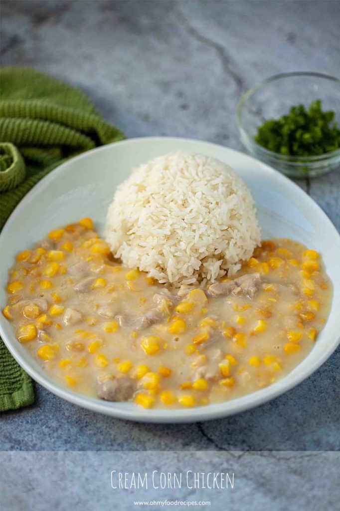 Cantonese cream corn and chicken with a scoop of rice on a white plate.