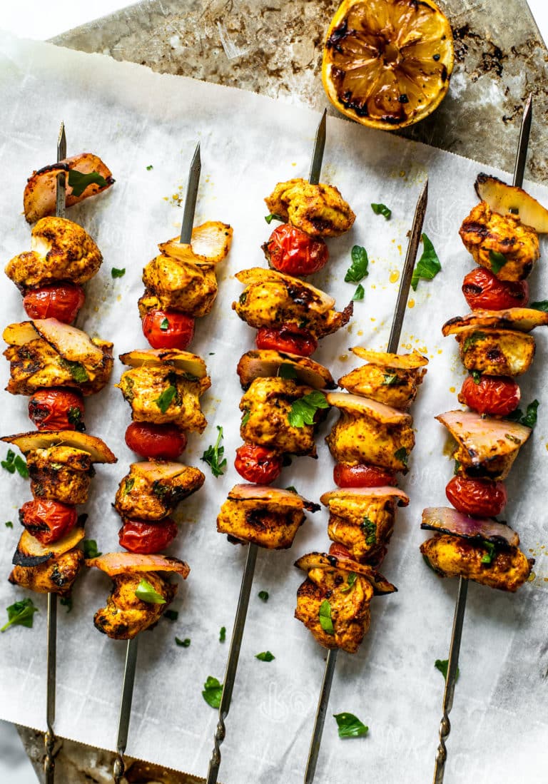 Grilled Moroccan chicken skewers on parchment paper.