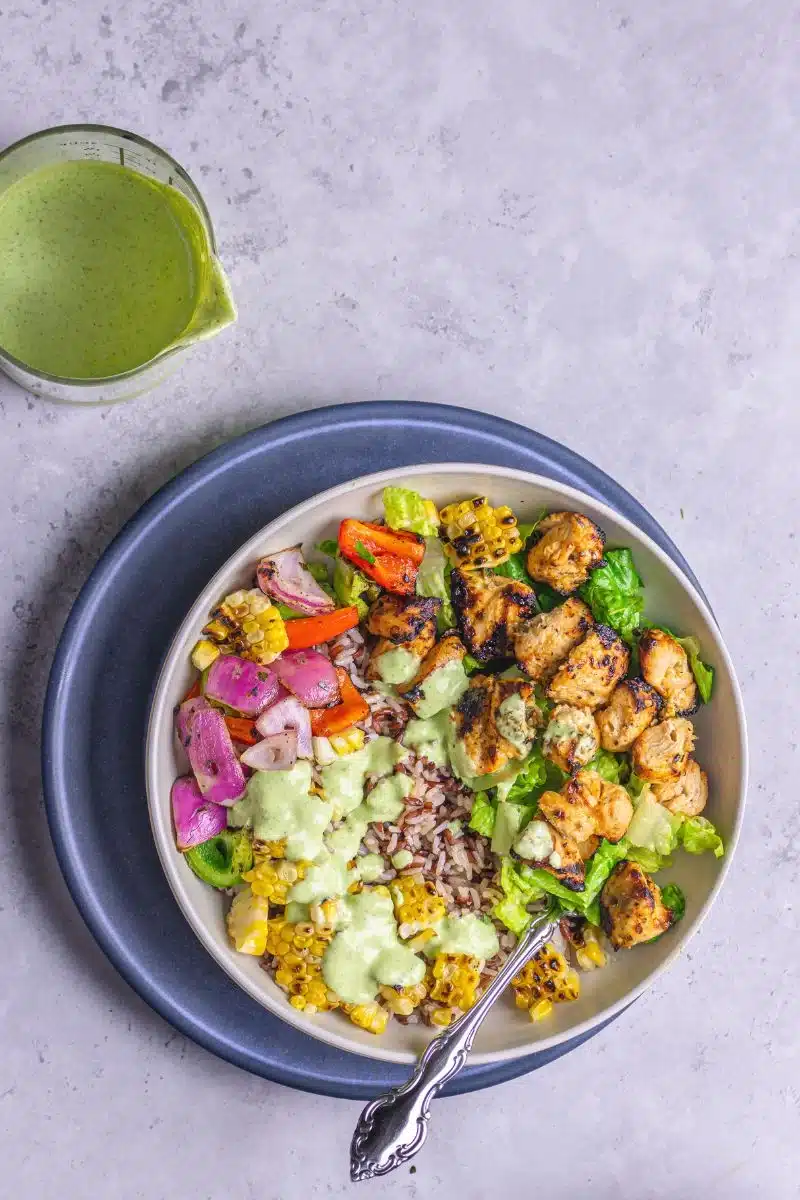 Greek chicken kebab bowl with green sauce.