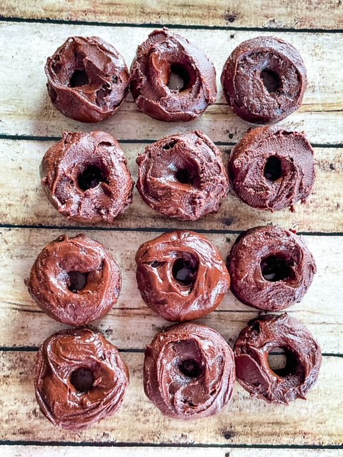 Mini Chocolate donuts on a wooden background.