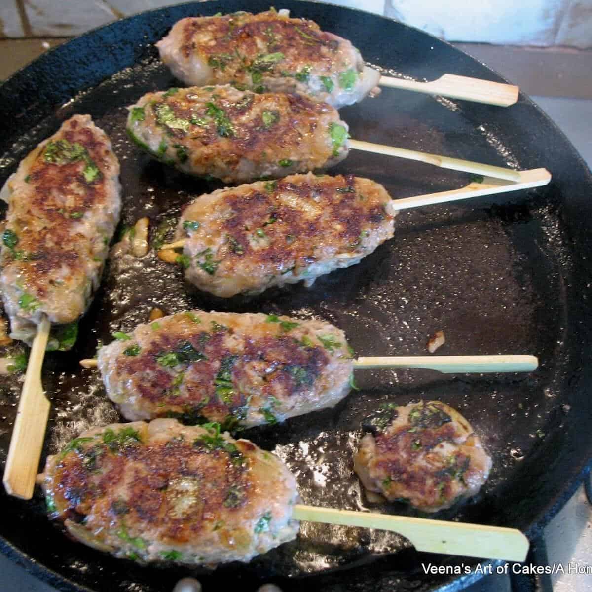 Ground turkey kababs in a cast iron pan.