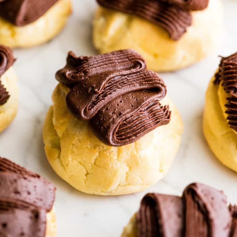 Homemade eclairs with chocolate frosting on top.