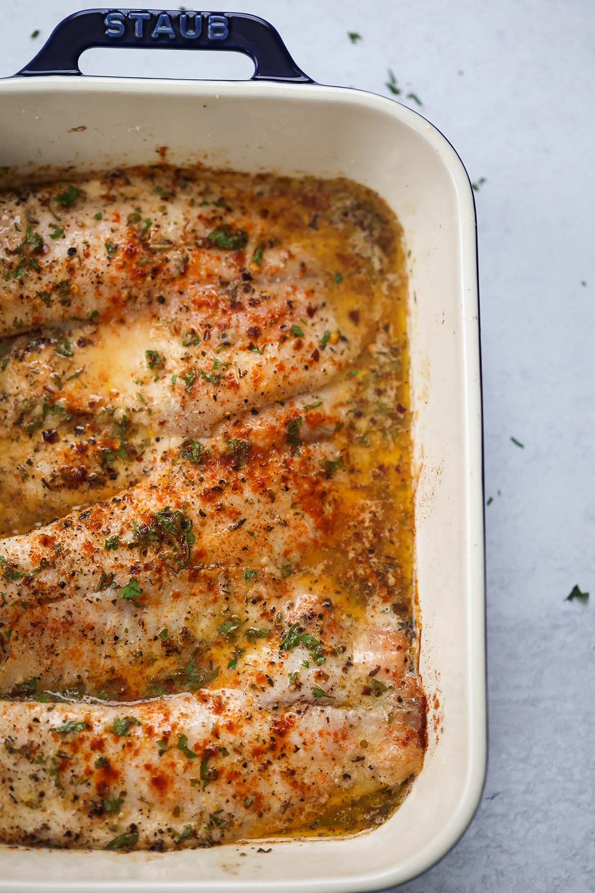 Lemon herb butter tilapia in a blue baking pan.