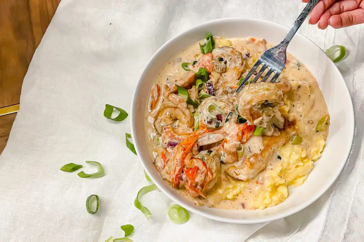 Creamy shrimp and polenta with blackened trout in a bowl.